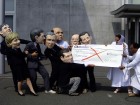 Costumed activists pretend to revoke aid cheque