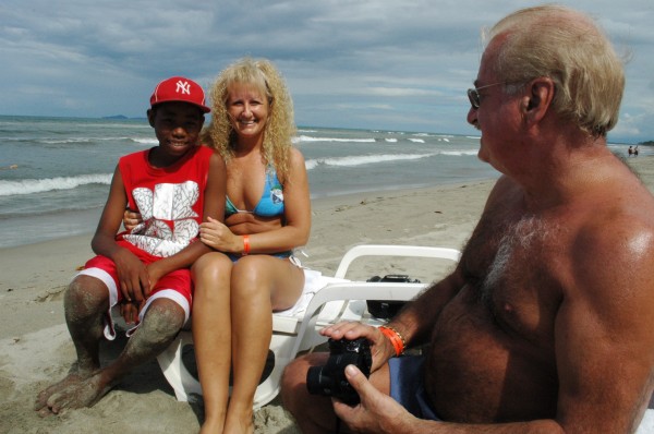 Québécois tourists in La Ceiba, with a Garifuna boy. Photo by Dawn Paley.