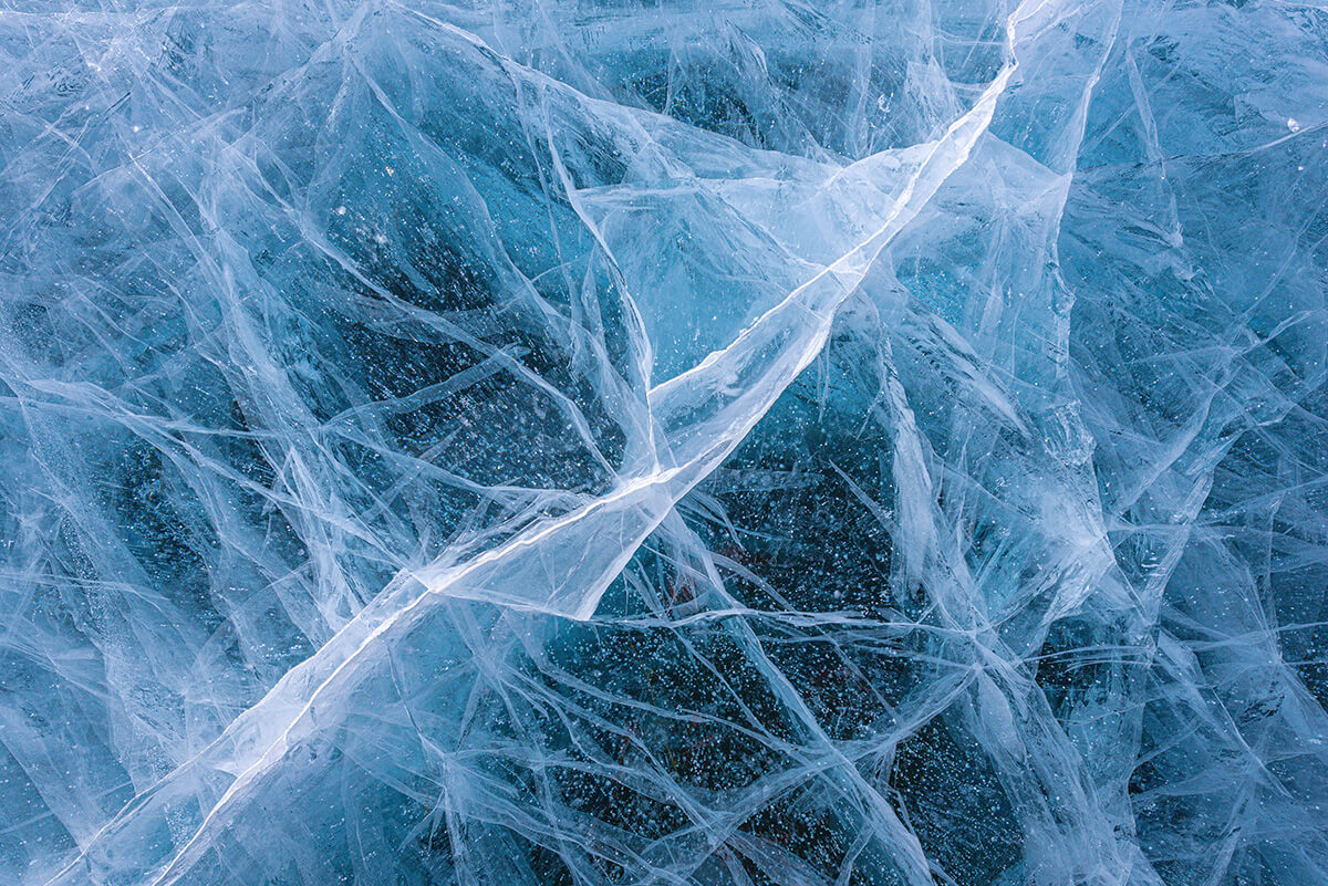 A close-up image of cracked blue ice.