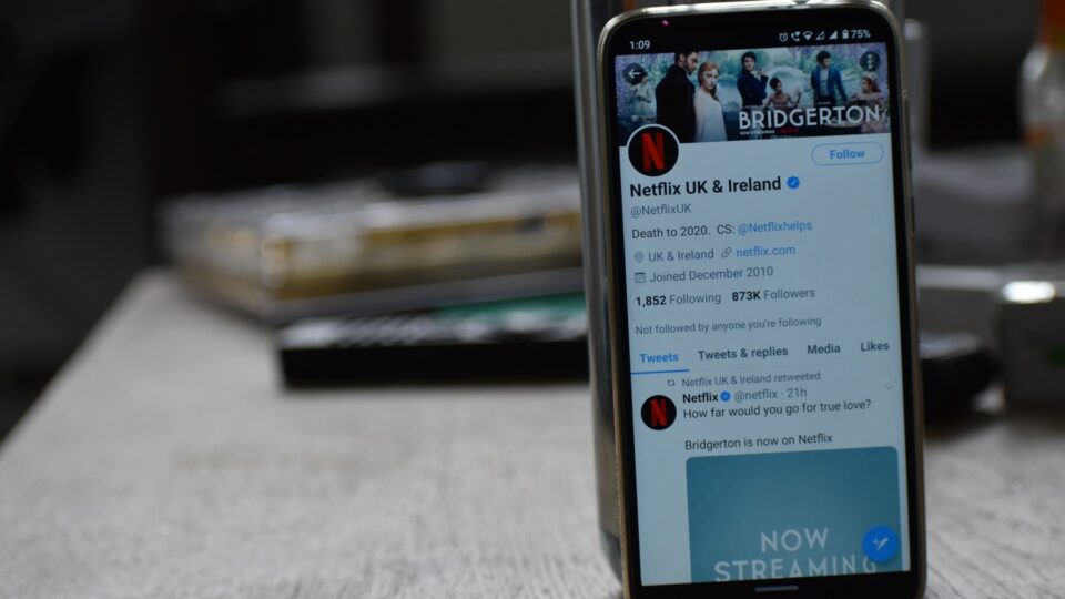 Closeup photo of a smartphone displaying Netflix's Twitter account with a Bridgerton banner.